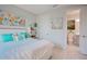 Bright bedroom with soothing turquoise accents, soft bedding, and en-suite bathroom access at 3008 Tolmino Ct, Lakewood Ranch, FL 34211