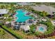 Stunning aerial view of the community pool area, complete with lounge chairs, umbrellas, and lush landscaping at 3008 Tolmino Ct, Lakewood Ranch, FL 34211