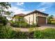 Well-manicured lawn with palm trees and landscaping leading up to the home at 3008 Tolmino Ct, Lakewood Ranch, FL 34211