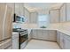 Bright kitchen features stainless steel appliances, modern gray cabinets, and stylish backsplash at 3008 Tolmino Ct, Lakewood Ranch, FL 34211