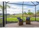 Screened-in patio features brick flooring, seating and pleasant view of the manicured lawn at 3008 Tolmino Ct, Lakewood Ranch, FL 34211