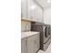 Well-lit laundry room featuring modern washer and dryer, cabinets, and sink with marble countertop at 3008 Tolmino Ct, Lakewood Ranch, FL 34211