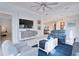 Well-lit living room featuring tile flooring, stylish furnishings, and an open layout with sightlines to the dining area at 3008 Tolmino Ct, Lakewood Ranch, FL 34211