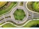 Bird's eye view of a roundabout featuring a green center with palm trees and meticulously maintained landscaping at 3008 Tolmino Ct, Lakewood Ranch, FL 34211