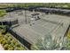Overhead shot of well-maintained tennis courts, complete with shaded benches and professional fencing at 3008 Tolmino Ct, Lakewood Ranch, FL 34211