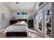 Bright and stylish bedroom with wood-look floors and French doors to the backyard at 3521 Almeria Ave, Sarasota, FL 34239