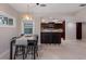 Bright dining area with an island and pendant lighting which flows into a kitchen with sleek countertops and dark cabinetry at 3521 Almeria Ave, Sarasota, FL 34239