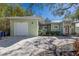 Exterior view of the home featuring light green siding, a red door, and a gravel driveway at 3521 Almeria Ave, Sarasota, FL 34239