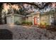 Charming home with a red door, surrounded by lush landscaping and a pea gravel driveway at 3521 Almeria Ave, Sarasota, FL 34239