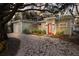 Charming single-story home with a landscaped yard, gravel driveway, and a vibrant red front door at 3521 Almeria Ave, Sarasota, FL 34239