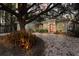 Charming single-story home with a red front door, manicured landscaping and a large tree in the front yard at 3521 Almeria Ave, Sarasota, FL 34239