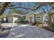 Charming home featuring a red front door, light green exterior, and pea gravel landscaping at 3521 Almeria Ave, Sarasota, FL 34239