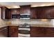 Dark wood cabinets and stainless steel appliances accent this well-lit kitchen with beautiful countertops and a mosaic backsplash at 3521 Almeria Ave, Sarasota, FL 34239