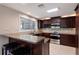 Stylish kitchen boasts granite countertops, dark wood cabinets, and stainless steel appliances at 3521 Almeria Ave, Sarasota, FL 34239