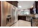 The kitchen shows stainless steel refrigerator and dark cabinets with granite countertops and mosaic backsplash at 3521 Almeria Ave, Sarasota, FL 34239