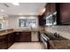 Stylish kitchen features granite countertops, dark wood cabinets, stainless steel appliances and mosaic backsplash at 3521 Almeria Ave, Sarasota, FL 34239
