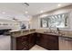 Bright kitchen area with stainless steel appliances, stone countertops, and dark cabinets at 3521 Almeria Ave, Sarasota, FL 34239