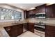 Modern kitchen featuring granite countertops, dark cabinetry, stainless steel appliances and mosaic backsplash at 3521 Almeria Ave, Sarasota, FL 34239