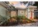 Lush landscaping detail of a charming green home with stone walkway and front pergola at 3521 Almeria Ave, Sarasota, FL 34239