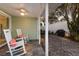Inviting covered patio with rocking chairs, ceiling fan, and outdoor lights and dining area at 3521 Almeria Ave, Sarasota, FL 34239