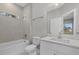 Bright bathroom featuring a tiled shower and tub, white cabinets, and a white quartz countertop at 36 Gilbert St, North Port, FL 34288