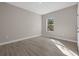 Clean bedroom with wood-look floors, a window with a street view, and white baseboards at 36 Gilbert St, North Port, FL 34288