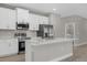 Contemporary kitchen featuring white cabinets, stainless steel appliances, and a central island at 36 Gilbert St, North Port, FL 34288