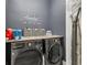 Modern laundry room with front-load washer and dryer, wood countertop and decorative wall art at 3645 Tin Cup Blvd, Sarasota, FL 34232
