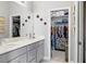 Bathroom featuring double sinks, a large mirror, and a walk-in closet with ample storage space at 3711 Manorwood Loop, Parrish, FL 34219