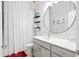Stylish bathroom with a round mirror, modern vanity, and patterned wallpaper at 3711 Manorwood Loop, Parrish, FL 34219