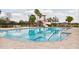 A community pool with a slide, palm trees, and lounge chairs creating a relaxing environment at 3711 Manorwood Loop, Parrish, FL 34219
