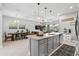 Bright, open kitchen featuring a large center island, granite countertops, and views into the living and dining areas at 3711 Manorwood Loop, Parrish, FL 34219
