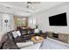 Inviting living room featuring a sectional couch, a large TV, and an open view to the dining room at 3711 Manorwood Loop, Parrish, FL 34219