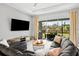 Comfortable living room with a large sectional sofa, a flat-screen TV, and sliding glass doors to the backyard at 3711 Manorwood Loop, Parrish, FL 34219