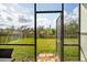 View from screened-in patio to a spacious yard and surrounding trees at 3711 Manorwood Loop, Parrish, FL 34219