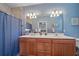Bathroom featuring a double sink vanity, a large mirror, and a blue shower curtain at 3760 82Nd Avenue E Cir # 101, Sarasota, FL 34243