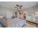 Bright bedroom with wood floors, a ceiling fan, television, and a view to the bathroom at 3760 82Nd Avenue E Cir # 101, Sarasota, FL 34243
