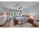 Bedroom with wood floors, ceiling fan, natural light, and modern furnishings at 3760 82Nd Avenue E Cir # 101, Sarasota, FL 34243