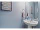 Charming half bathroom with a stylish pedestal sink and blue accent wall at 3760 82Nd Avenue E Cir # 101, Sarasota, FL 34243