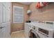 Functional laundry room with washer, dryer, and storage shelves at 3760 82Nd Avenue E Cir # 101, Sarasota, FL 34243