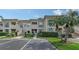 Inviting multi-level condo featuring a well-maintained facade, lush landscaping, and convenient parking at 4429 Longmeadow # 49, Sarasota, FL 34235