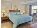 Relaxing bedroom features a comfy bed with blue quilt, two side tables and a work area by the window at 4440 47Th W Ave # 204, Bradenton, FL 34210
