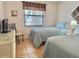 Comfortable bedroom with two twin beds, tile floors, and a wicker dresser with television at 4440 47Th W Ave # 204, Bradenton, FL 34210