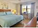 Light-filled bedroom with a bed featuring a blue quilt, curtains, and a dedicated workspace at 4440 47Th W Ave # 204, Bradenton, FL 34210