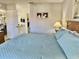 Well lit bedroom includes ensuite bathroom and seating area adjacent to a bed with blue cover at 4440 47Th W Ave # 204, Bradenton, FL 34210