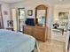 Bedroom featuring a dresser with a TV, mirror, and access to a private balcony at 4440 47Th W Ave # 204, Bradenton, FL 34210