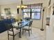 Bright dining area featuring a glass table, elegant chandelier, and natural light from the window at 4440 47Th W Ave # 204, Bradenton, FL 34210