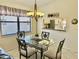 Dining area with a glass table, seating for four, and a view into the kitchen at 4440 47Th W Ave # 204, Bradenton, FL 34210