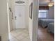 Entrance hall with white door, decorative mirror and a glimpse into the bedroom with twin beds at 4440 47Th W Ave # 204, Bradenton, FL 34210