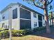 Exterior view of condo with screened lanais surrounded by a tree lined lawn at 4440 47Th W Ave # 204, Bradenton, FL 34210